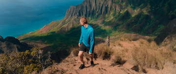 Man hiking wearing a blue Vapor Apparel Thermal Hoodie
